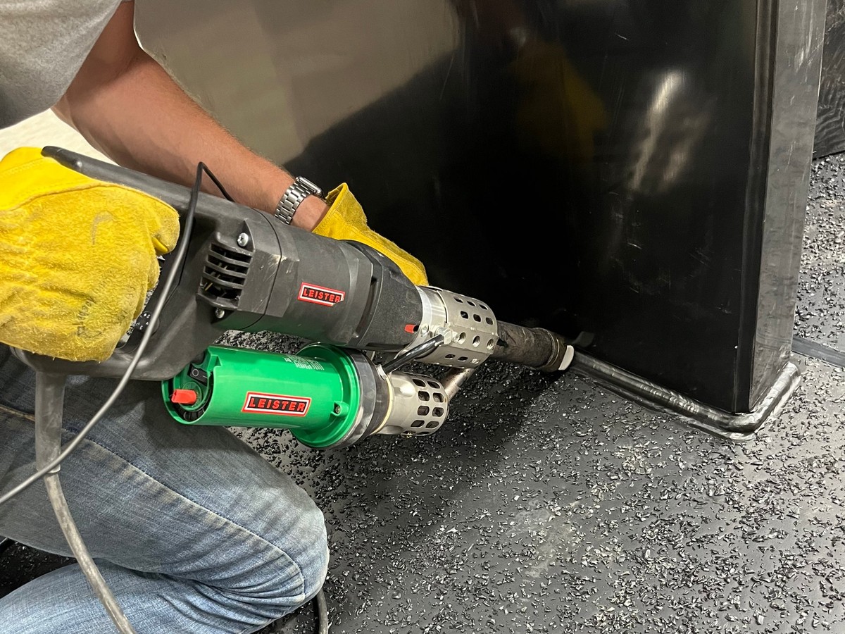 Handheld extrusion welder finishing a welded assembly